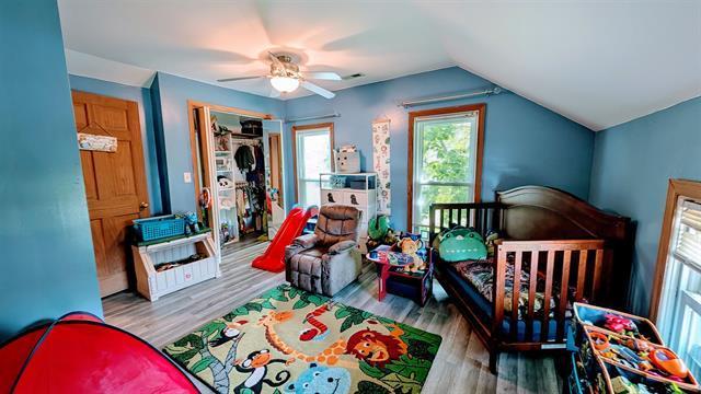 bedroom featuring wood finished floors, lofted ceiling, and a ceiling fan