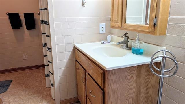 bathroom featuring vanity, a shower with shower curtain, tile walls, and tile patterned flooring