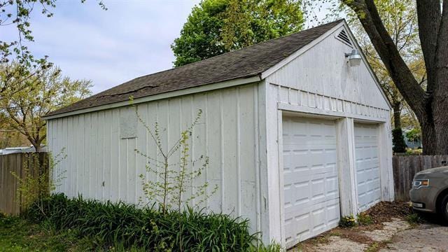 detached garage featuring fence