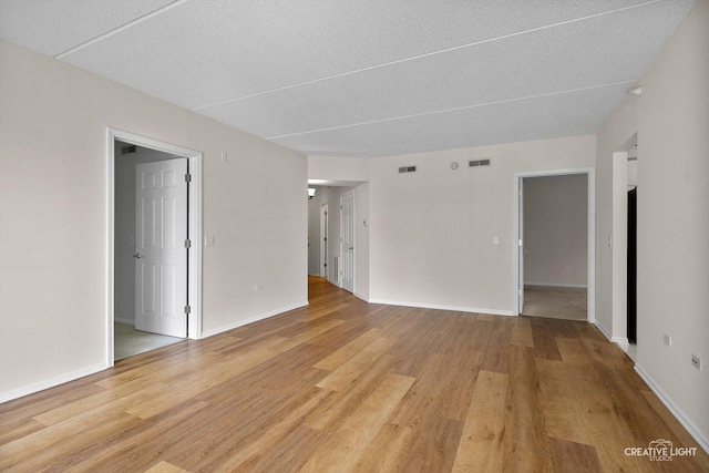 100 N Gary Ave Unit 308, Wheaton, IL 60187 - spare room with light wood finished floors, baseboards, and a textured ceiling