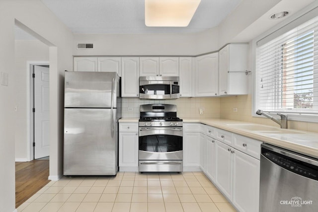 100 N Gary Ave Unit 308, Wheaton, IL 60187 - kitchen featuring stainless steel appliances, white cabinetry, a sink, tasteful backsplash, and light countertops