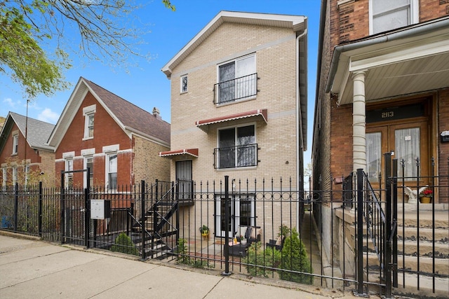 view of front facade featuring brick siding and a fenced front yard