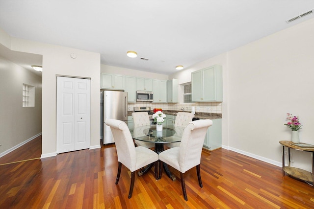 dining area featuring dark wood-style flooring and baseboards