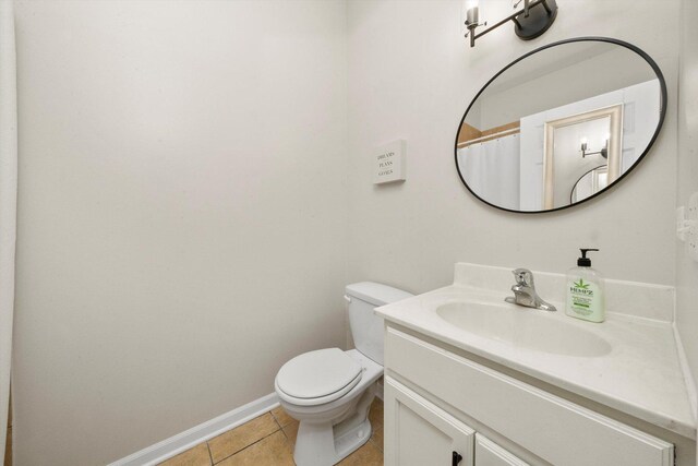bathroom featuring tile patterned floors, vanity, toilet, and baseboards