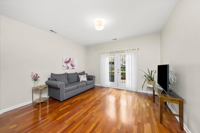 living room featuring wood finished floors, french doors, and baseboards