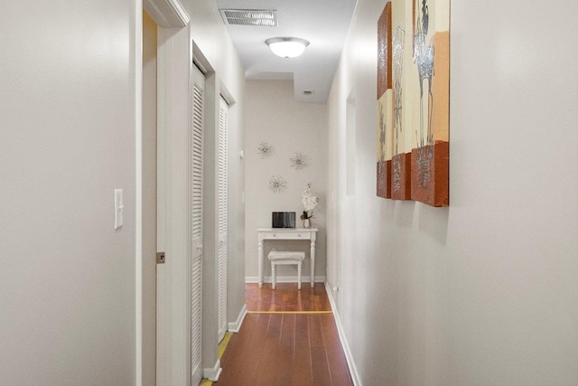 hallway featuring wood finished floors and baseboards