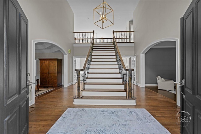 4N749 Old Farm Rd, Saint Charles, IL 60175 - foyer entrance with arched walkways, a high ceiling, stairway, a chandelier, and dark wood finished floors
