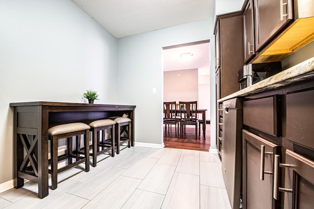 hall featuring light wood-style floors and baseboards