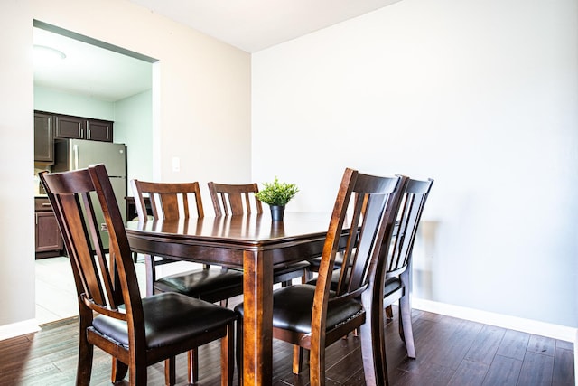 dining space with baseboards and dark wood-style flooring