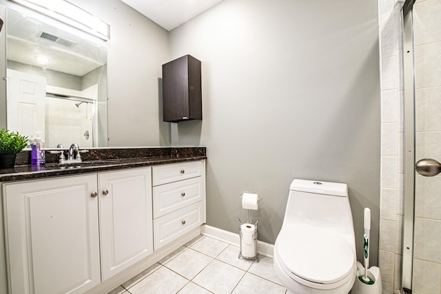 full bathroom with a stall shower, toilet, tile patterned floors, vanity, and baseboards