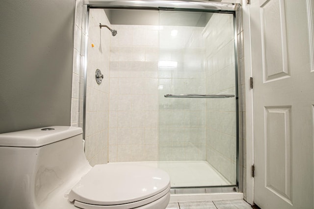 bathroom featuring toilet and a stall shower