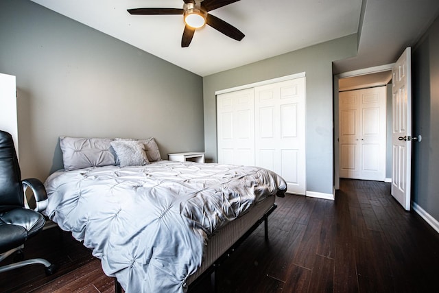 bedroom with dark wood-type flooring, a closet, baseboards, and a ceiling fan