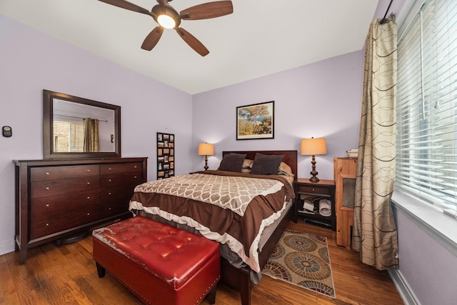 bedroom with wood finished floors, multiple windows, and baseboards