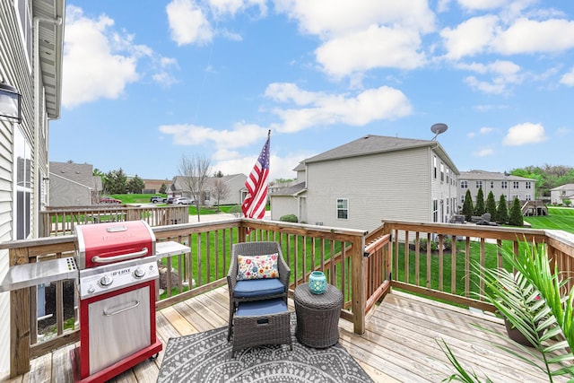 wooden deck with a residential view, a lawn, and grilling area