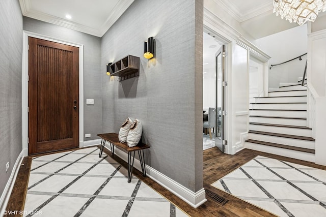entrance foyer featuring inlaid floor details, light wood-style flooring, stairs, crown molding, and baseboards