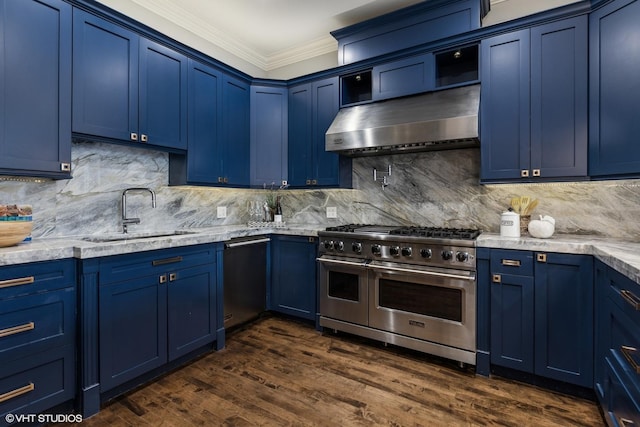 kitchen with stainless steel appliances, blue cabinetry, a sink, ornamental molding, and wall chimney exhaust hood