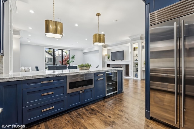 kitchen with built in appliances, blue cabinets, open floor plan, wine cooler, and crown molding