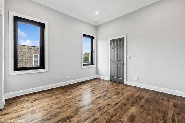 empty room featuring dark wood finished floors, baseboards, crown molding, and recessed lighting