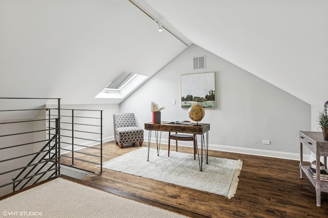 home office featuring wood finished floors, baseboards, a skylight, rail lighting, and lofted ceiling