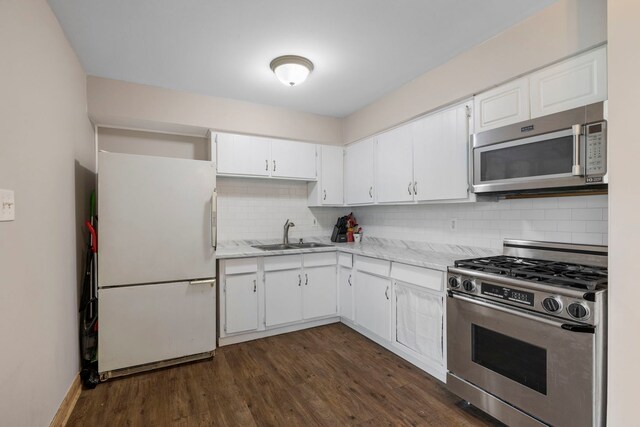 kitchen with stainless steel appliances, a sink, tasteful backsplash, white cabinetry, and dark wood-style flooring
