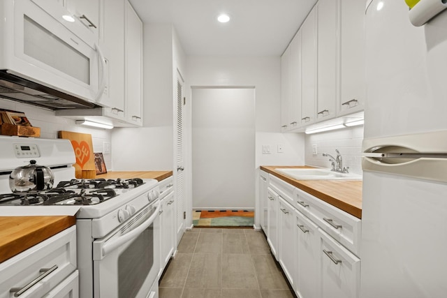 921 W Gunnison St Unit 1W, Chicago, IL 60640 - kitchen featuring white appliances, wooden counters, a sink, tasteful backsplash, and white cabinets