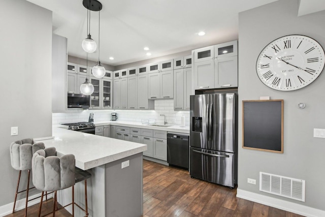 443 E 45th Pl Unit 3, Chicago, IL 60653 - kitchen with appliances with stainless steel finishes, a peninsula, a sink, baseboards, and backsplash