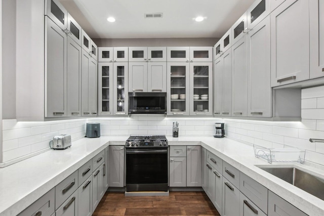 443 E 45th Pl Unit 3, Chicago, IL 60653 - kitchen featuring appliances with stainless steel finishes, gray cabinets, light countertops, decorative backsplash, and recessed lighting