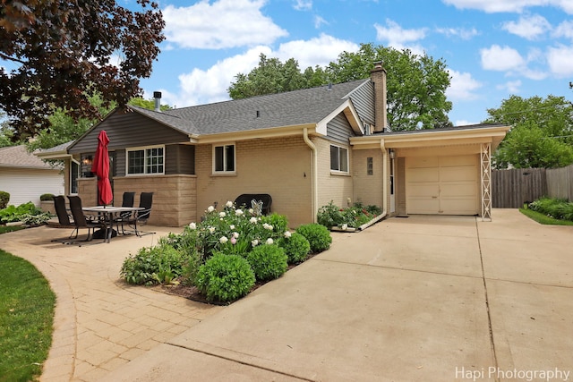 1129 Longmeadow Dr, Glenview, IL 60025 - view of front of property with driveway, a chimney, a garage, brick siding, and a shingled roof