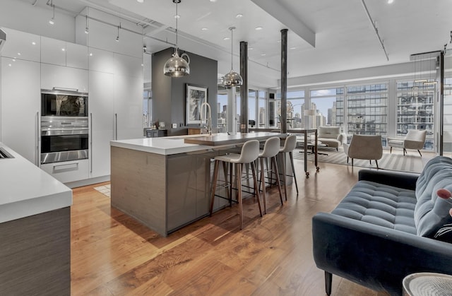 333 N Canal St Unit 3401, Chicago, IL 60606 - kitchen featuring appliances with stainless steel finishes, open floor plan, modern cabinets, white cabinetry, and light wood-style flooring