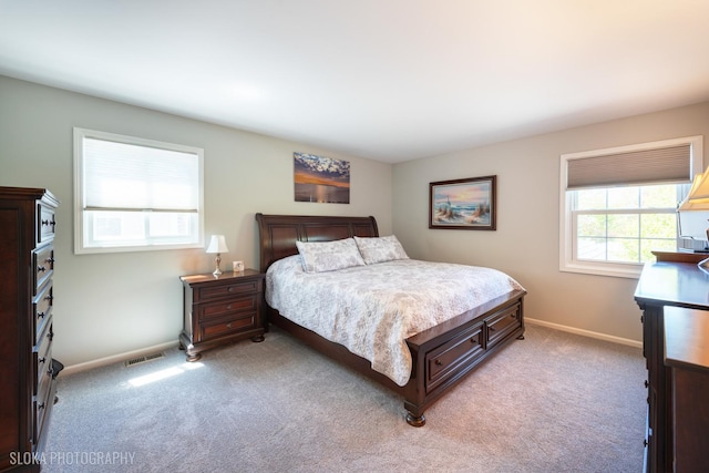 bedroom featuring light carpet and baseboards