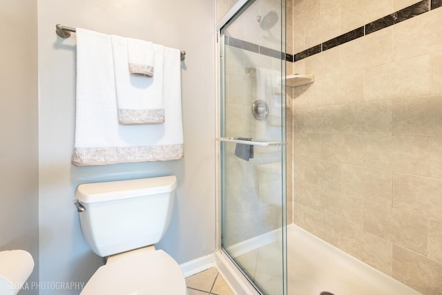 bathroom featuring toilet and a shower stall