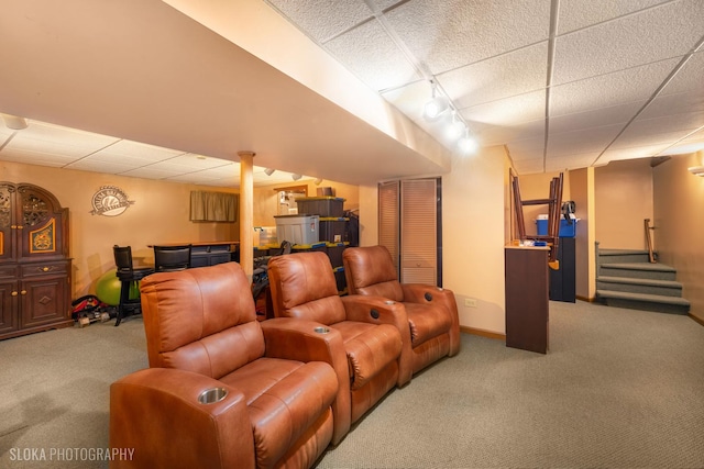 home theater featuring carpet floors, rail lighting, a drop ceiling, and baseboards