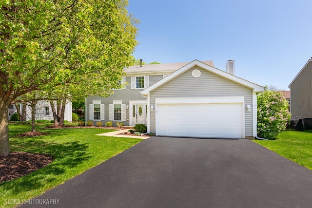 view of front of house with a front lawn, asphalt driveway, a garage, and a chimney