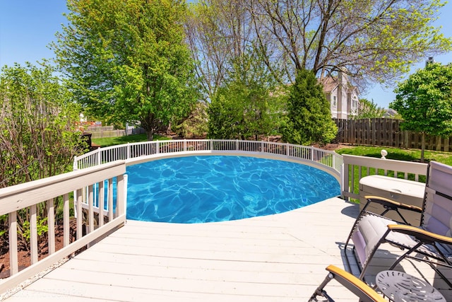 view of swimming pool with a fenced backyard and a deck
