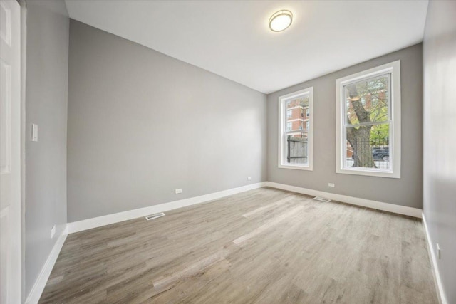 spare room featuring light wood finished floors and baseboards