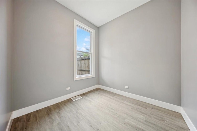 spare room featuring baseboards and light wood-style flooring