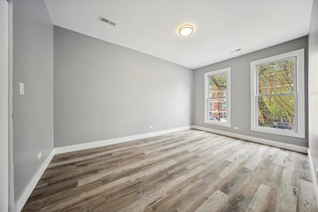 empty room featuring wood finished floors and baseboards