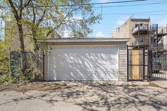 detached garage featuring fence and a gate