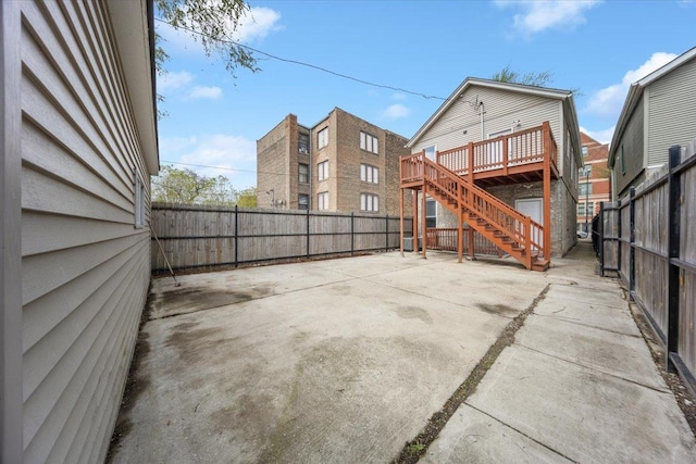 rear view of house with stairs, a fenced backyard, a patio, and a wooden deck
