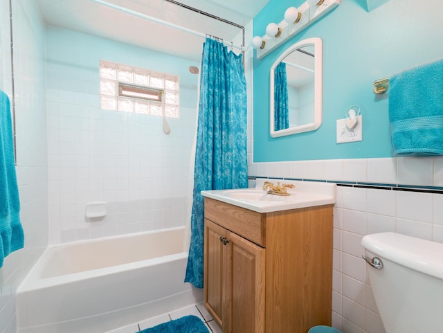 2504 W St, River Grove, IL 60171 - bathroom featuring vanity, shower / tub combo with curtain, toilet, tile walls, and a wainscoted wall