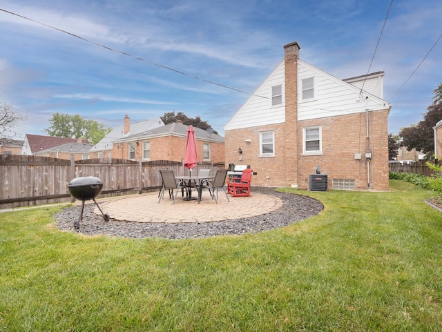 2504 W St, River Grove, IL 60171 - rear view of house featuring cooling unit, a chimney, brick siding, and a patio area