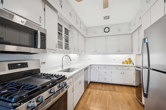 2472 W Estes Ave Unit 2, Chicago, IL 60645 - kitchen featuring stainless steel appliances, a sink, light wood-type flooring, light countertops, and white cabinets