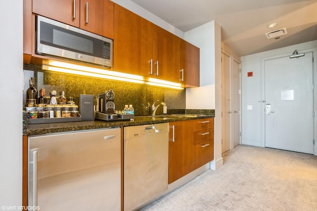 401 N Wabash Ave Unit 2534, Chicago, IL 60611 - kitchen with stainless steel appliances, backsplash, dark stone countertops, and brown cabinets