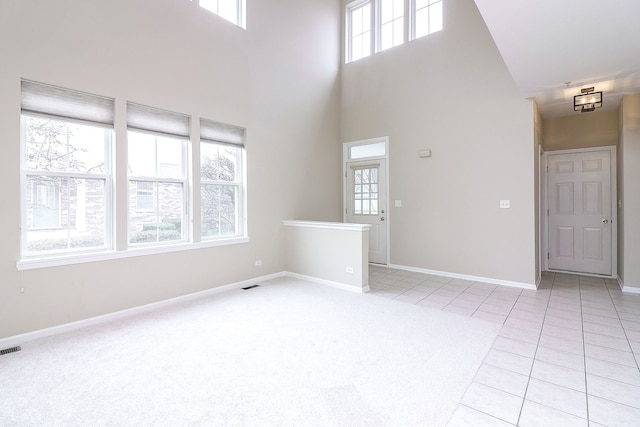 140 Tanglewood Dr, Glen Ellyn, IL 60137 - empty room featuring a high ceiling, baseboards, light tile patterned floors, and light carpet