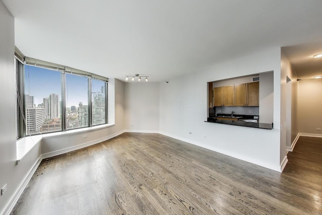 400 N Lasalle St Unit 2207, Chicago, IL 60654 - unfurnished living room with wood finished floors, a sink, baseboards, and track lighting