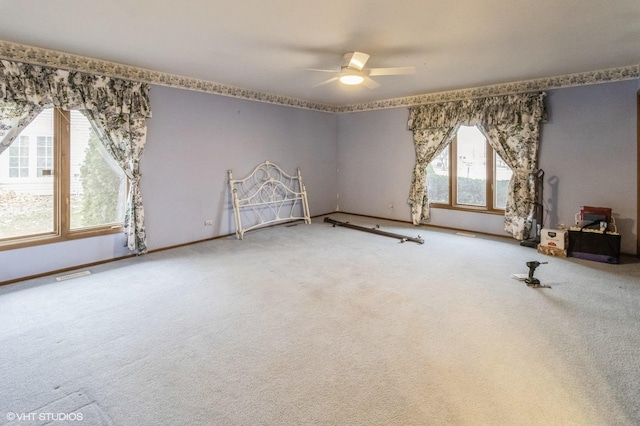 empty room featuring ceiling fan, baseboards, and carpet