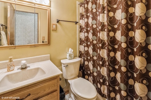 bathroom featuring vanity, toilet, and curtained shower