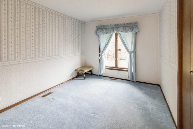 empty room with wallpapered walls, carpet floors, and baseboards