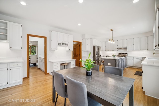dining area featuring light wood finished floors, recessed lighting, and a chandelier