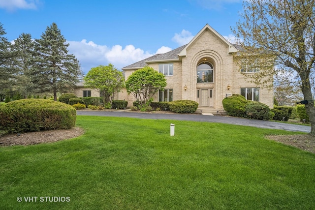 view of front of house featuring a front lawn and brick siding
